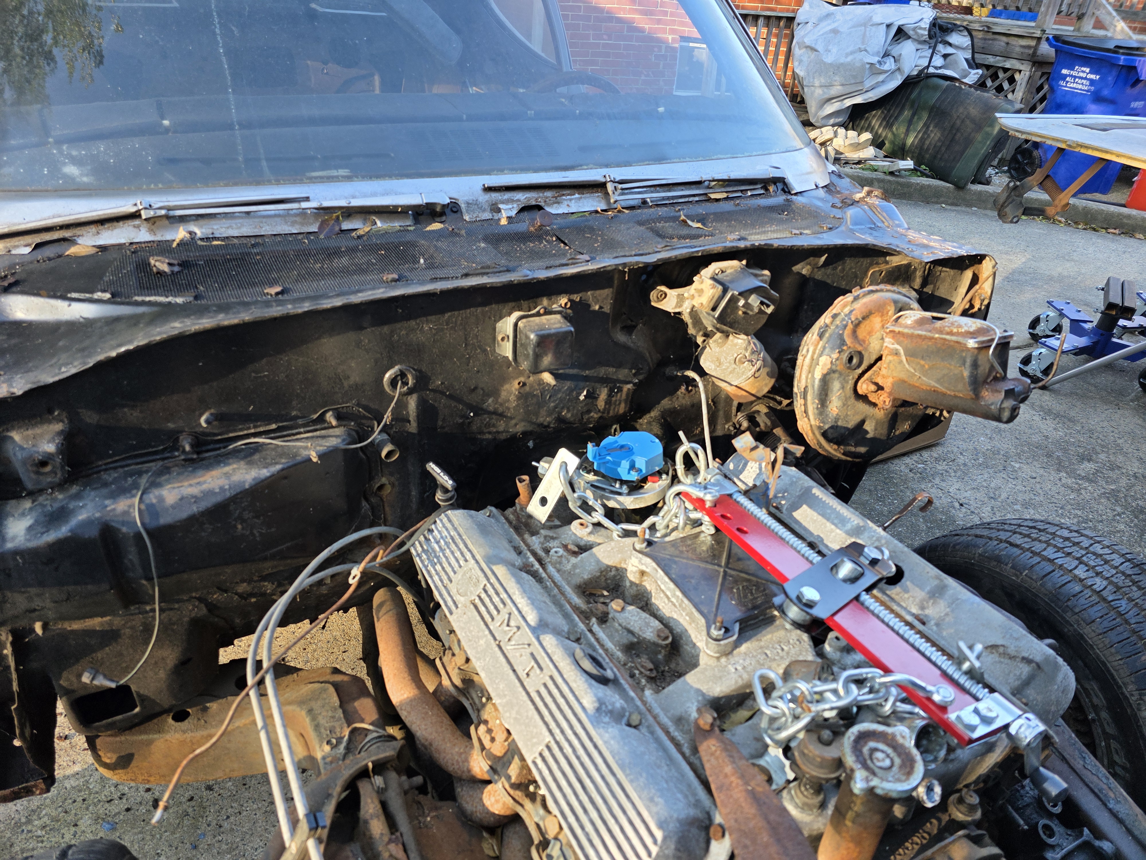 Oldsmobile Rocket 350 with Mickey Thompson finned aluminum valve covers rigged to an engine leveler, front sheetmetal removed.